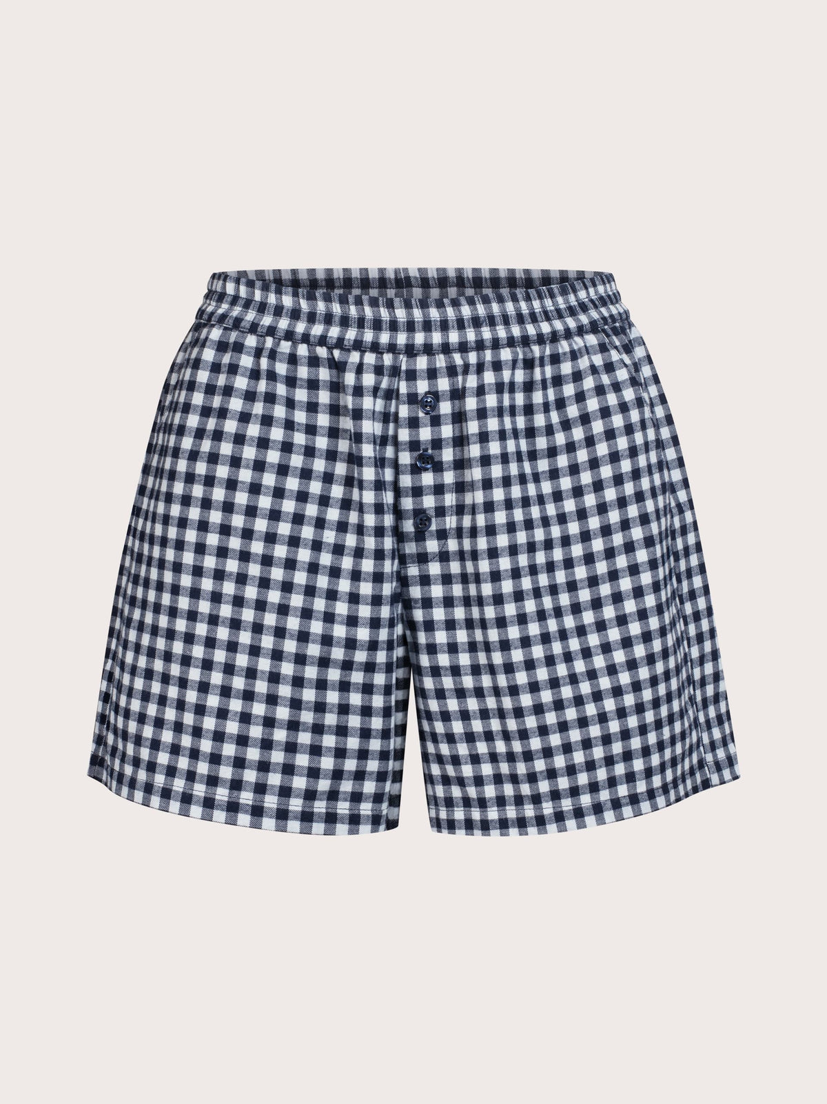 A pair of women's shorts featuring a navy and white gingham check pattern, an elastic waistband, and three decorative buttons down the front, displayed on a solid light beige background.